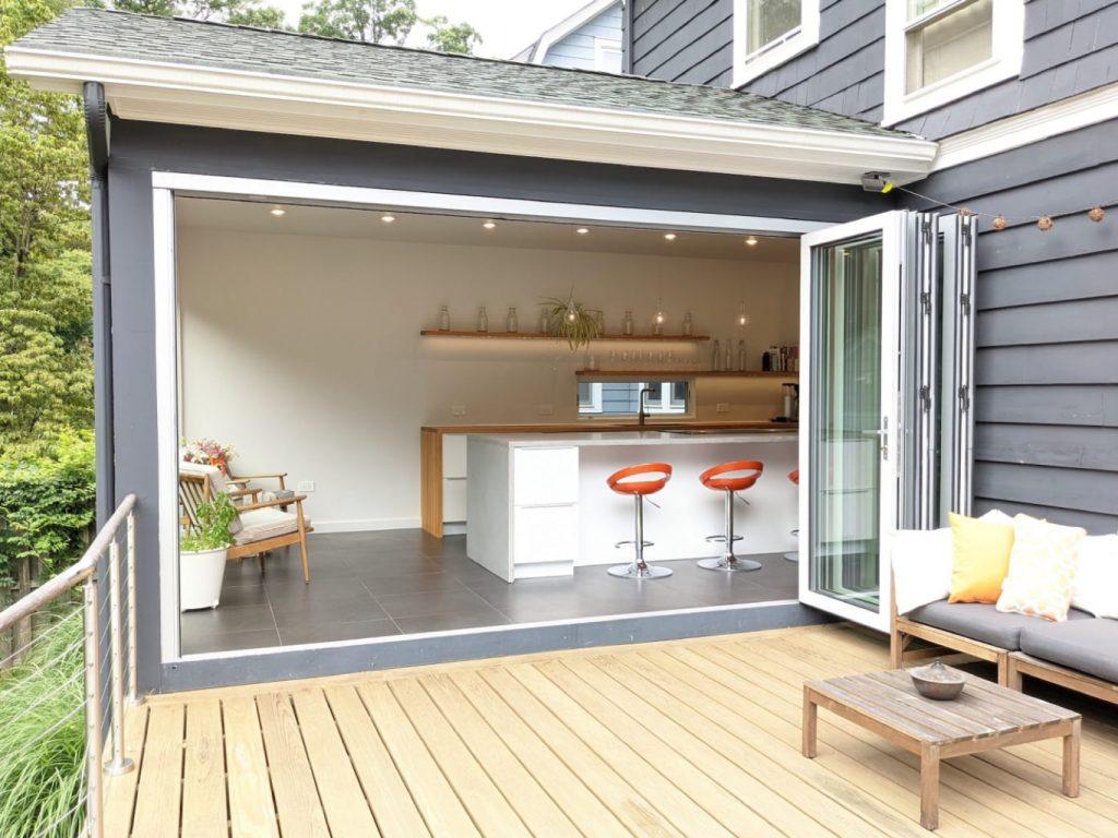 Biophilic architecture—modern bifold doors open kitchen to outdoor deck entertainment space