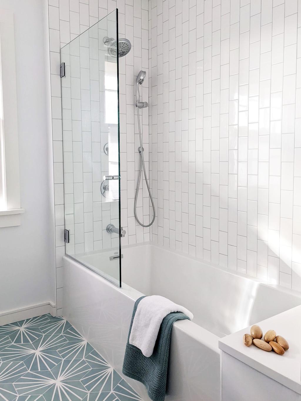 MCM mid century modern bathroom has vertical white subway tile, gray grout and a modern chrome shower