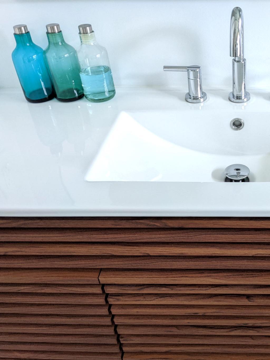 MCM mid century modern bathroom with acacia wood vanity, integrated sink and modern chrome faucet