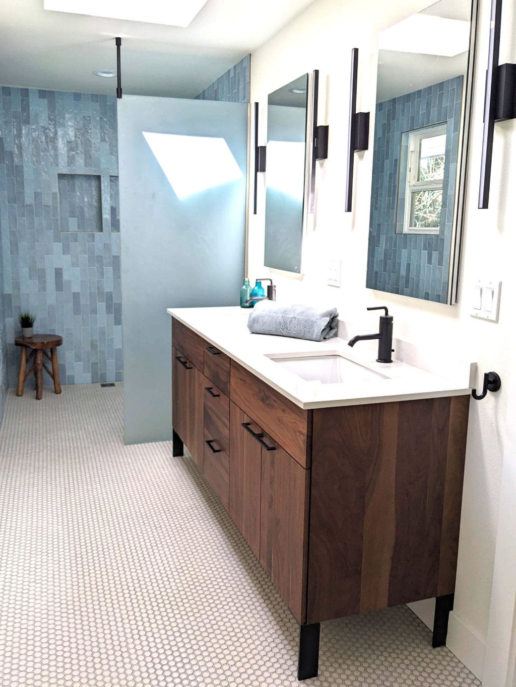 Bathroom renovation with level access shower and LED lights, matte black faucets